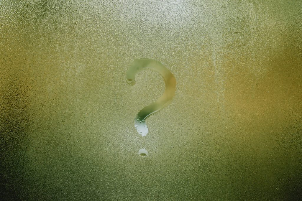 wet transparent misted window with question mark